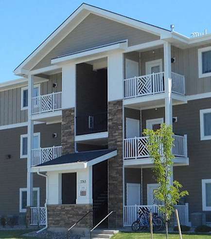 Apartment building with balconies and doors.