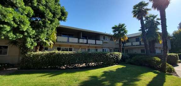 an apartment building with palm trees in front of it