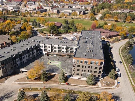 an aerial view of a campus with a lake and buildings