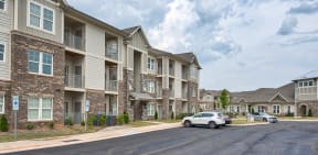 Apartment building with cars parked in front.