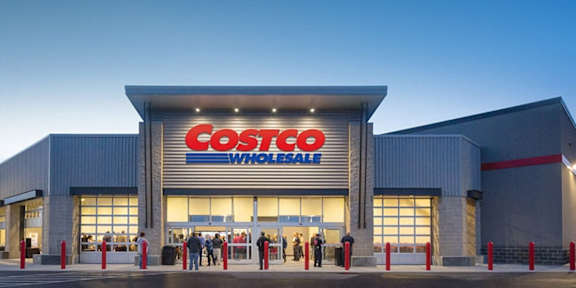 A Costco Wholesale store with people standing in front.