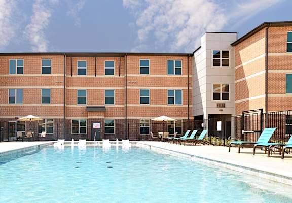 a large swimming pool in front of a building  at The Liberty Lofts, Gainesville, TX, 76240