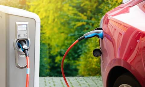 An electric car is being charged at a station.