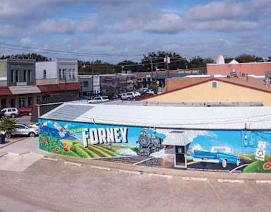 A street view of a town with a Forney sign on a building.