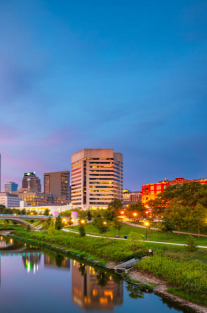 A city skyline at dusk with a river running through it.