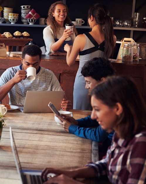 Group of people are sitting around a wooden table in a café, using laptops and drinking coffee at Rivers at Bluegrass, Kentucky