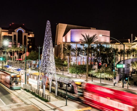 a city street at night with a christmas tree and a bus at Mark at 87 Apartments, Mesa, AZ 85201