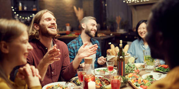 A group of people are gathered around a table enjoying a meal together.
