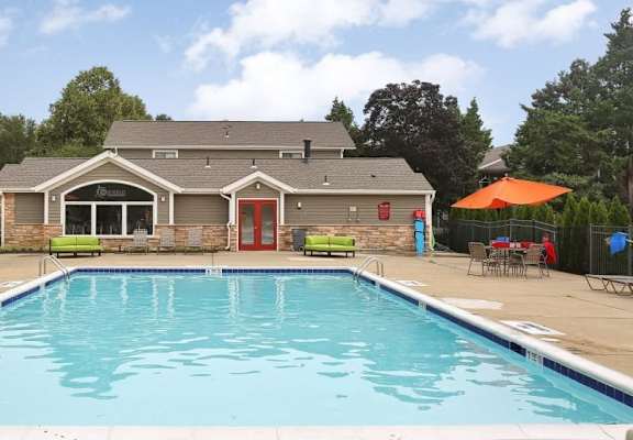 a swimming pool with a house in the background