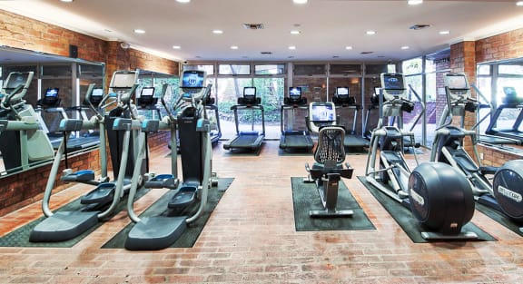 a gym with cardio equipment and windows in a building at The Meadows Apartments, Culver City , CA 90230