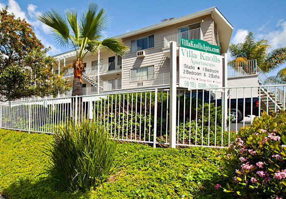a large white fence in front of a building with a sign that reads villa acacia