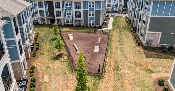 an aerial view of an apartment complex with a fenced in yard