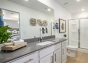 Thumbnail 6 of 10 - A bathroom with a white toilet, a sink, and a shower.