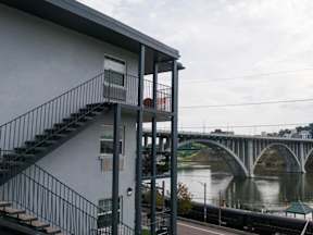 A bridge over a river with a house and stairs in the foreground.at Maplehurst Apartments, Knoxville