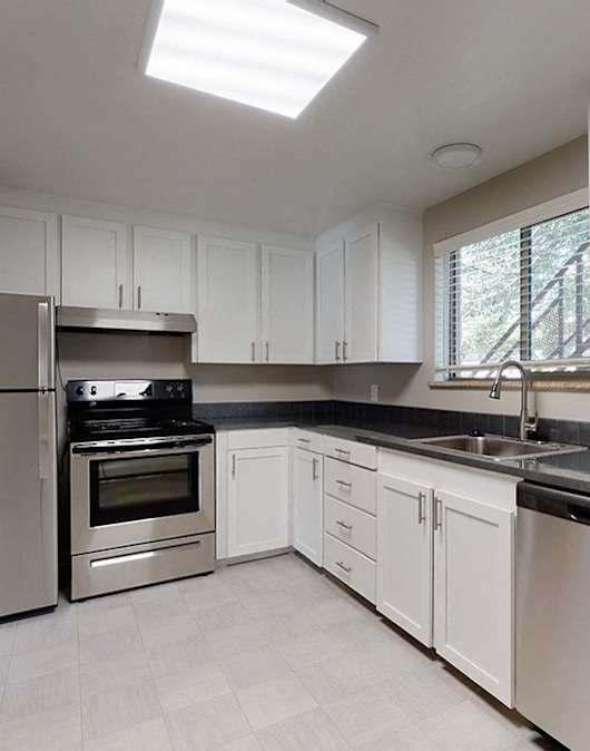 A modern kitchen with stainless steel appliances and white cabinets.