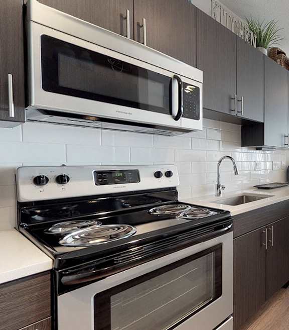 A modern kitchen with a bar area and a painting on the wall.
