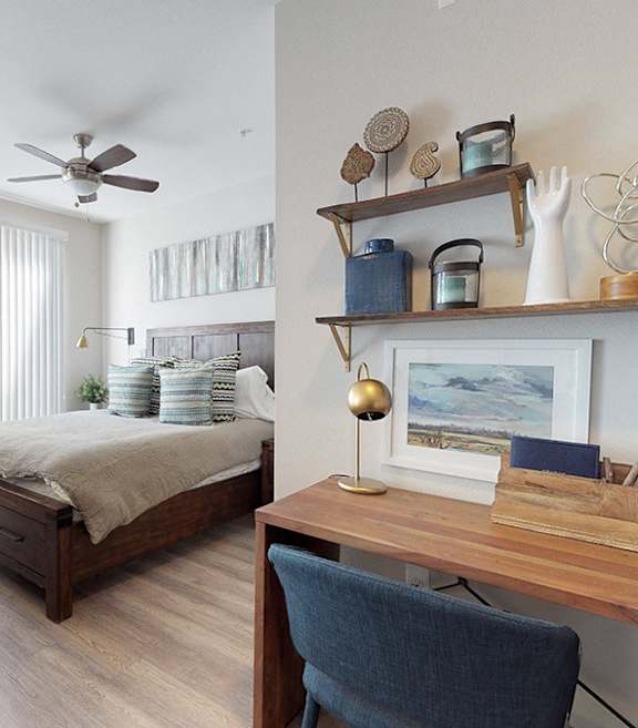 A bedroom with a bed, a chair, and a desk.
