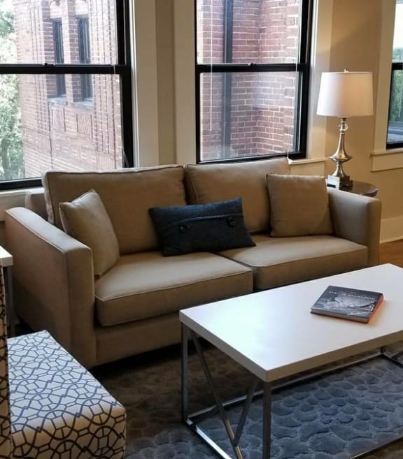 a living room with a couch coffee table and a refrigerator