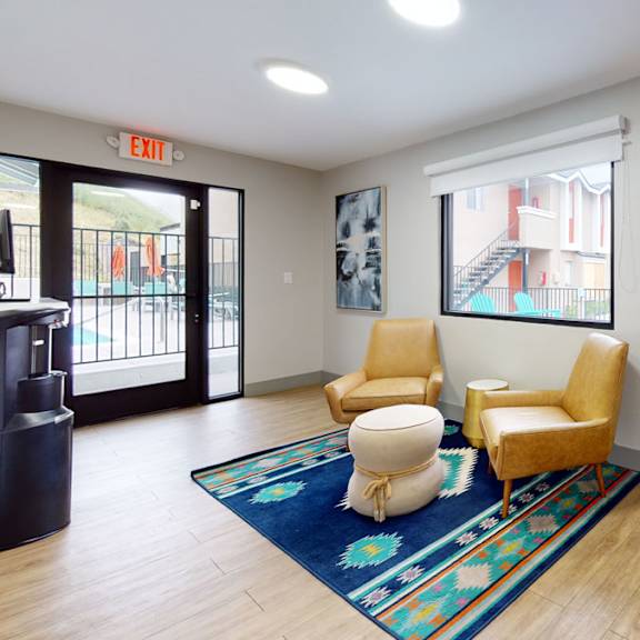 The front office longue with true chairs, a coffee table, and a footstool at Hillside Village. 
