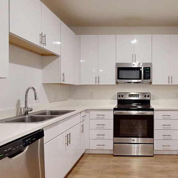 a modern kitchen with white cabinets and stainless steel appliances