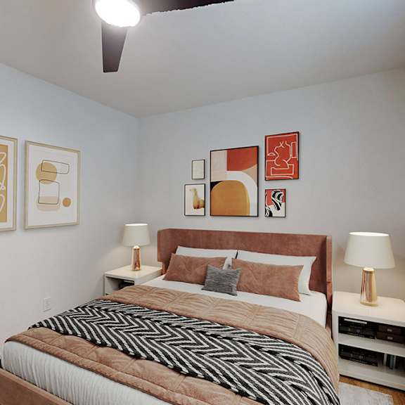A bedroom with a bed, two lamps, and artwork on the wall.