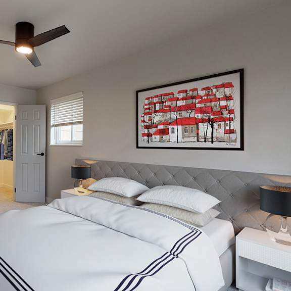 A bedroom with a large bed and a ceiling fan.