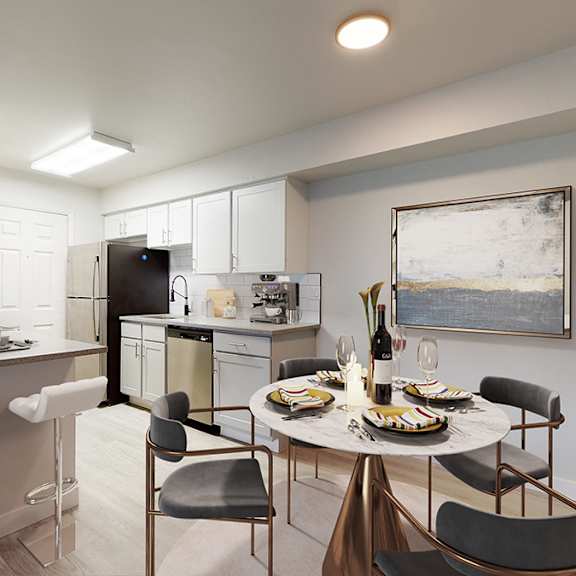 A modern kitchen with a dining table set for two.
