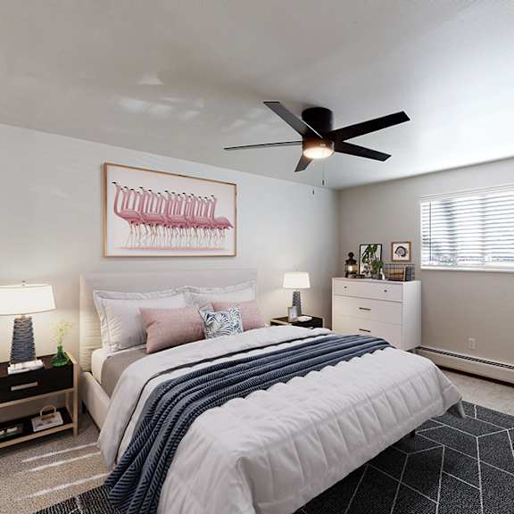 A bedroom with a bed, a chair, and a ceiling fan.