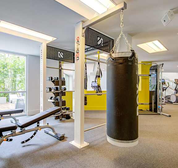 A gym with a punching bag and weights. at Baker Block, California, 92626