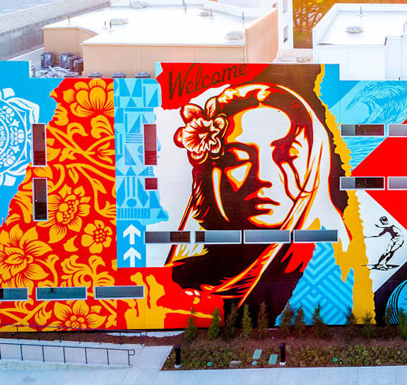 A mural of a bird with outstretched wings is painted on the side of a building. at Baker Block, Costa Mesa, California