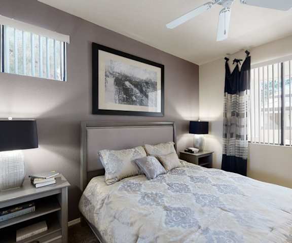 A bedroom with a queen-size bed, a dresser, decorations, window, and nightstands at Natura Villas Apartments. 