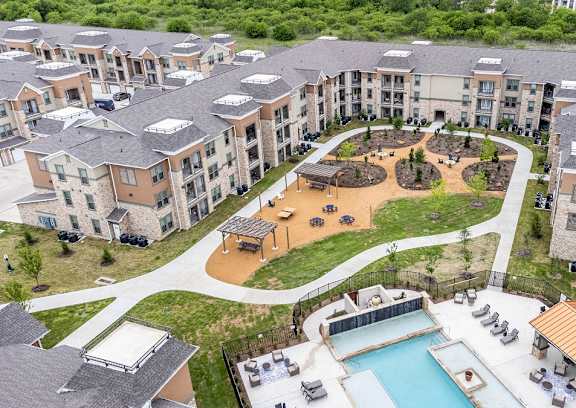 An aerial view of apartment buildings with a pool and a playground.