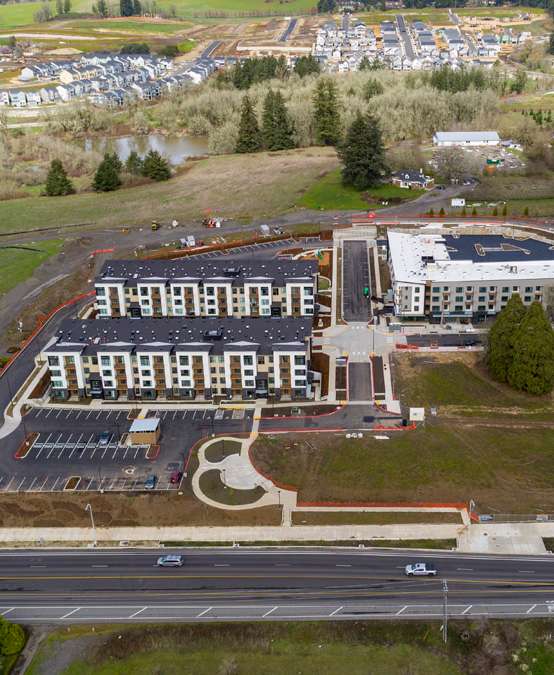 An aerial view of a large building with a parking lot in front of it.