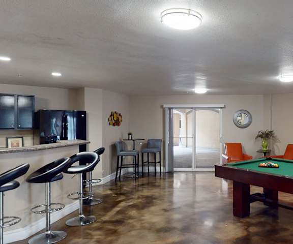 A resident lounge with tables, chairs, and a pool table at Citifront Apartments.