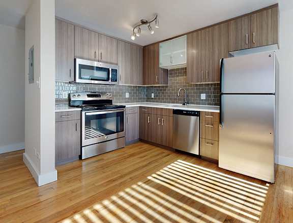 A kitchen with wooden floors and stainless steel appliances.
