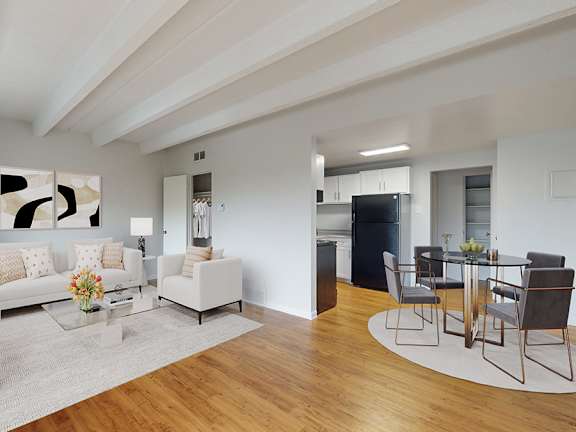 A modern living room with white furniture and a wooden floor.