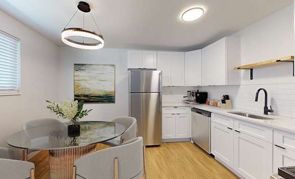 A modern kitchen with a glass table and stainless steel appliances.