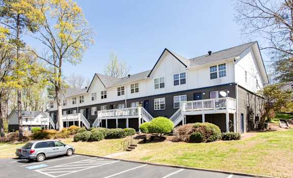 A grey and white building with a car parked in front at Barcelo at East Cobb Apartments, Marietta, GA, 30067