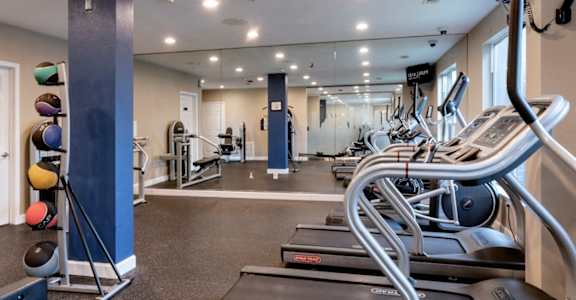 a gym with cardio equipment and weights in a building