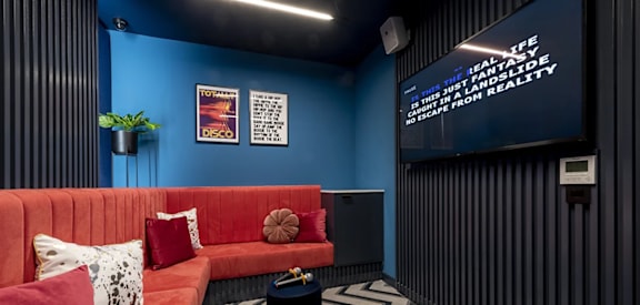 a living room with a red couch and a television