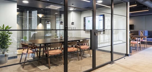 a conference room with tables and chairs and glass walls