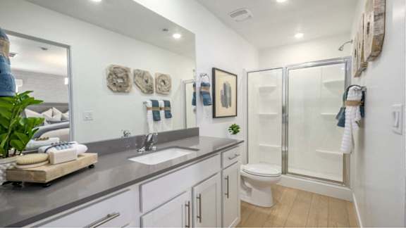 A bathroom with a white toilet, a sink, and a shower.
