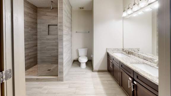 A bathroom with a walk-in shower, toilet, and sink.