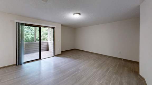 A room with a sliding glass door leading to a balcony.