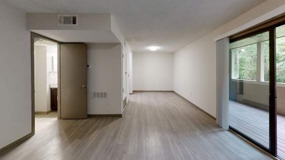 A room with a wooden floor and a sliding glass door.
