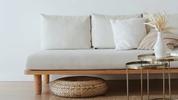 A modern living room with a grey sofa, a black floor lamp, and a grey rug.