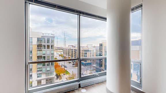 a floor to ceiling window with a view of midtown crossing from the living room of the 2-bedroom Tuscon