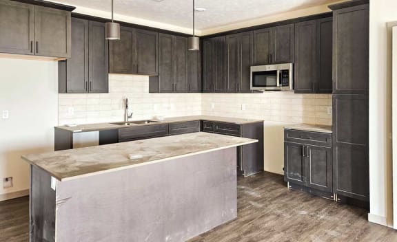 a kitchen with a marble counter top and black cabinets