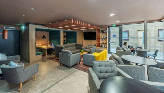 A modern lounge area with grey and yellow accent chairs.