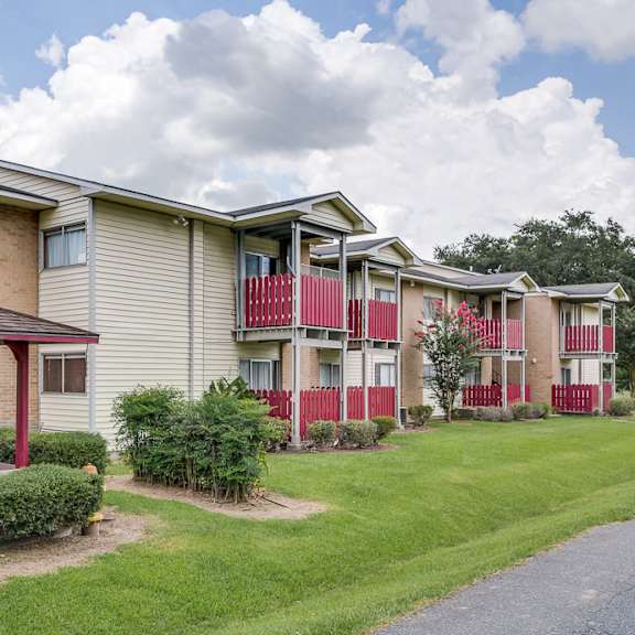 A row of apartment buildings with a red and white building in the front.